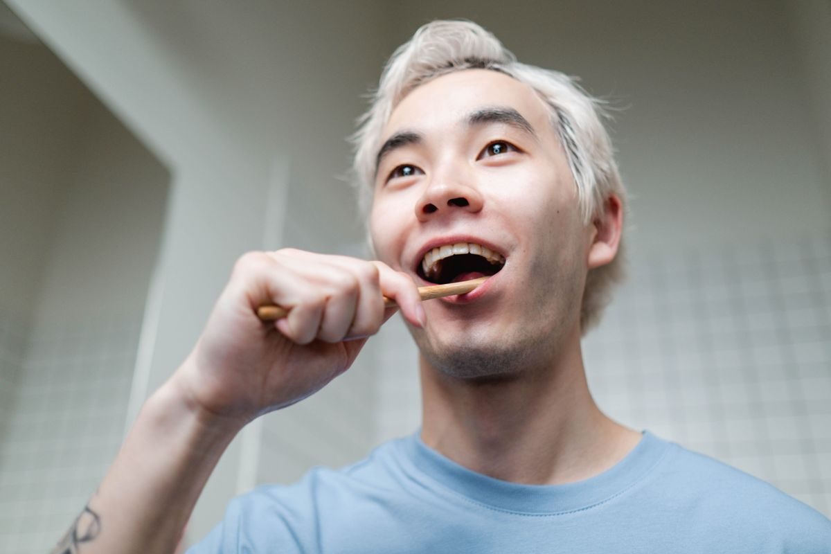 洗面所で歯を磨く男性(音波振動歯ブラシの使用イメージ)