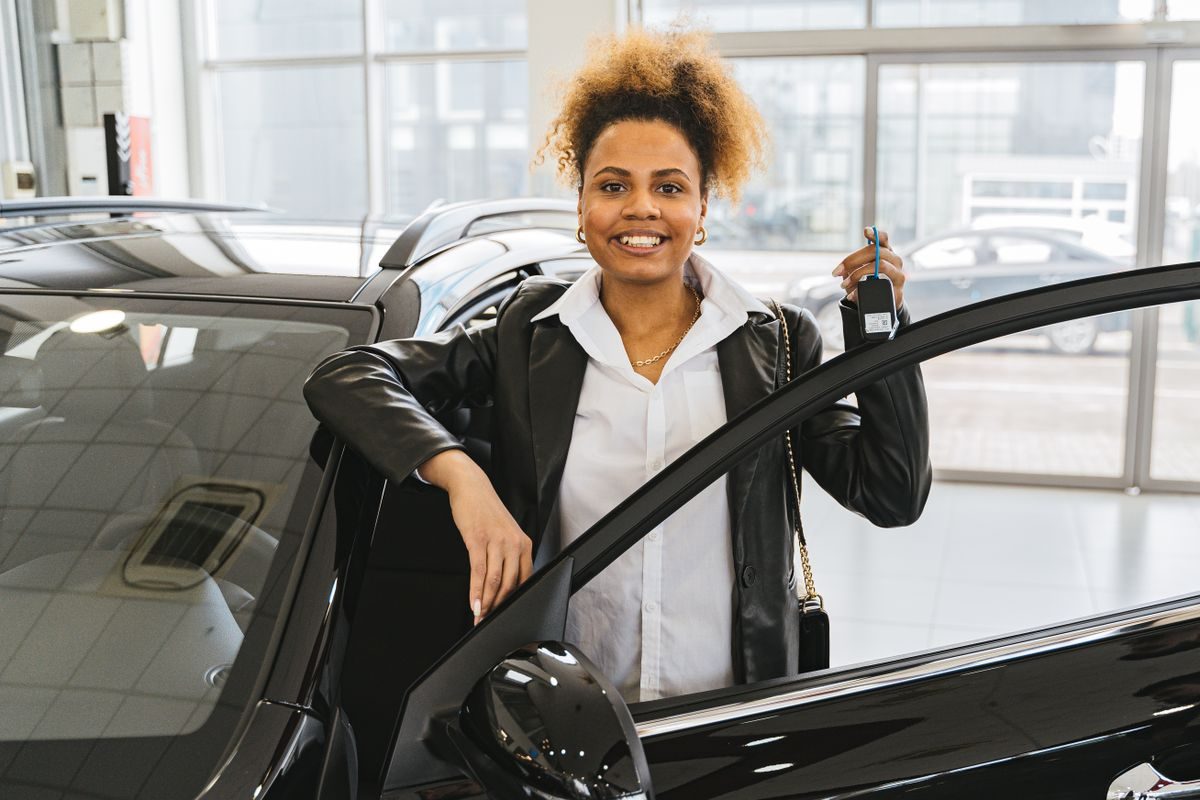新車の鍵を手にする女性(カーリース契約イメージ)