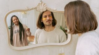 鏡の前でスキンケアをするカップル