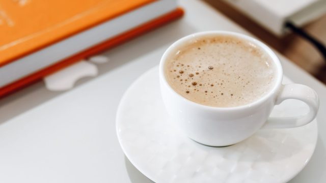 コーヒーとノートのある明るい学習デスク