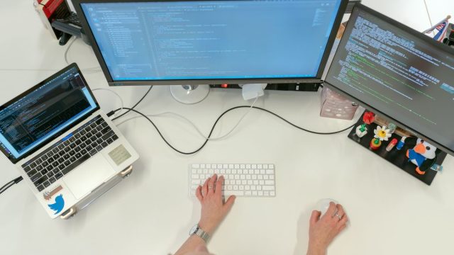 デュアルモニターでコーディングする女性エンジニア