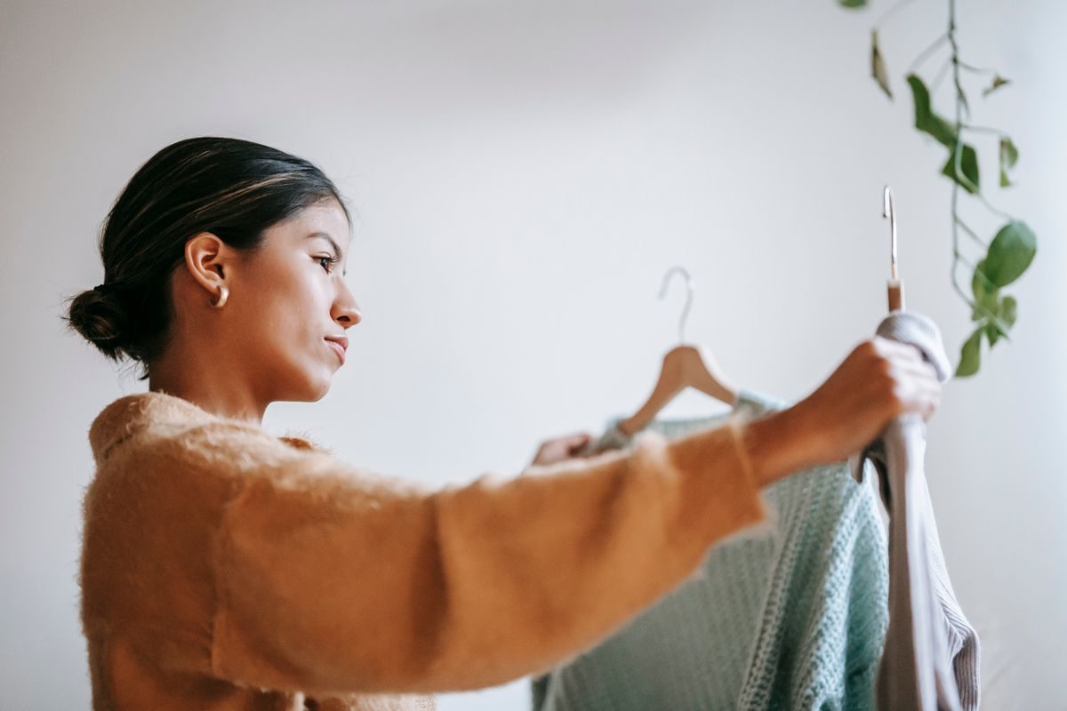 自宅で服を選ぶ女性(メチャカリのファッションレンタルイメージ)