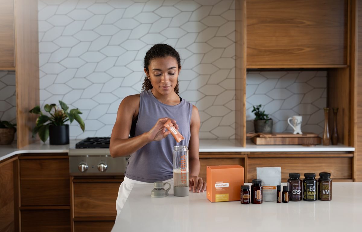 キッチンでドリンクを用意する女性(浄水型サーバーの活用イメージ)