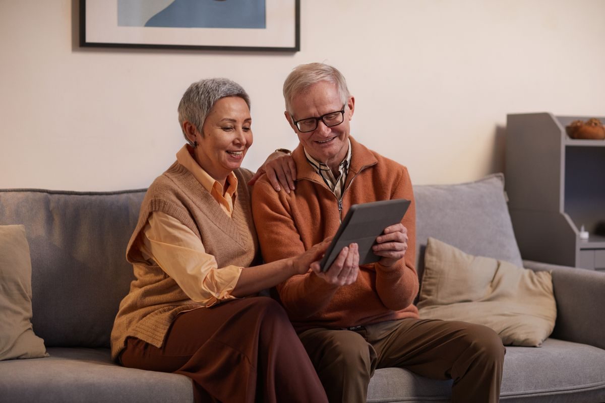 ソファでタブレットを一緒に見るカップル|誌面を見ながらの会話も雑誌の良さ