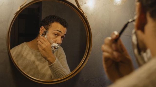 鏡の前でシェービングする男性(メンズスキンケアイメージ)