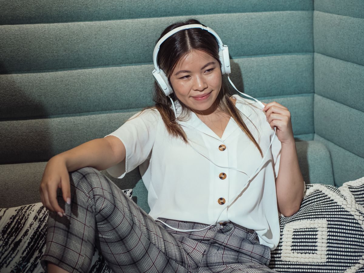 ソファで音楽を楽しむ女性(音楽配信イメージ)