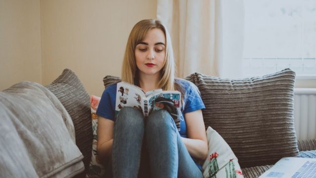 ソファで読書を楽しむ女性(電子書籍・読み放題)