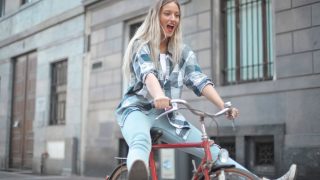 自転車で街を走る女性|電動アシストで坂道も快適