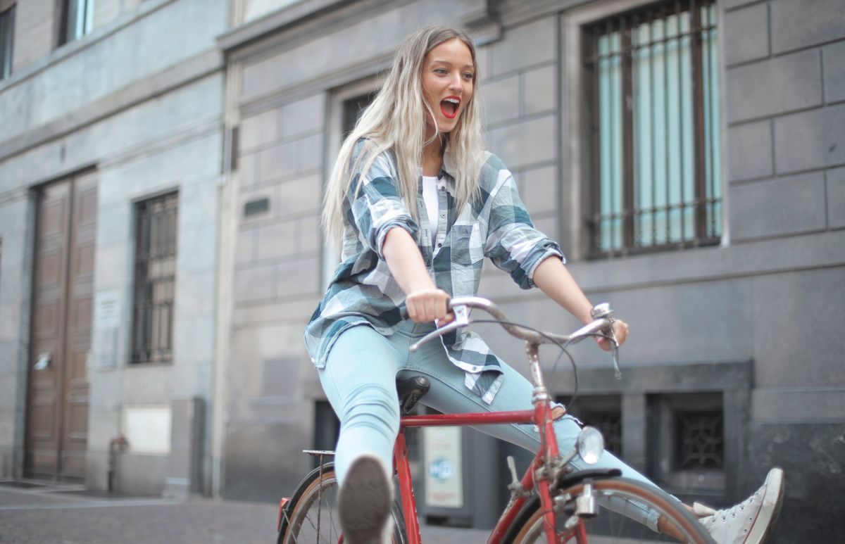 自転車で街を走る女性|電動アシストで坂道も快適