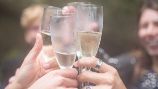 ワイングラスを傾けて乾杯する様子|ポケットソムリエのワイン選びイメージ