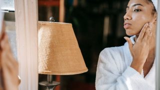 鏡の前でスキンケアする女性