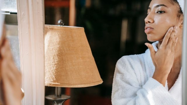 鏡の前でスキンケアする女性