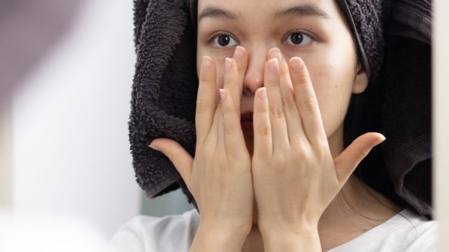鏡の前でスキンケアする女性
