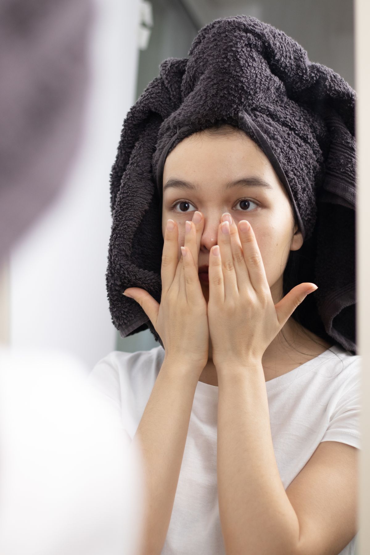 鏡の前でスキンケアする女性