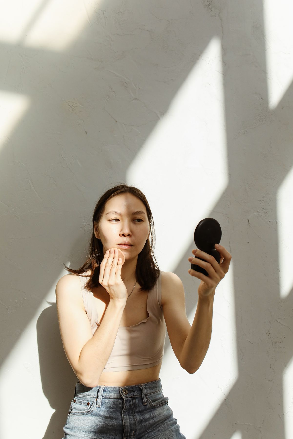 鏡の前でスキンケアする女性