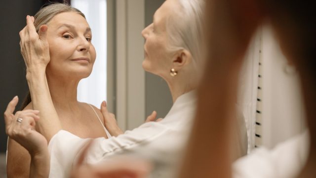 鏡の前でスキンケアする女性