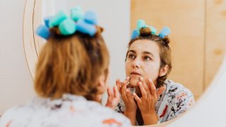 鏡の前でスキンケアする女性
