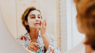 鏡の前でスキンケアする女性