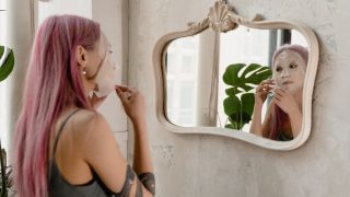 鏡の前でスキンケアする女性