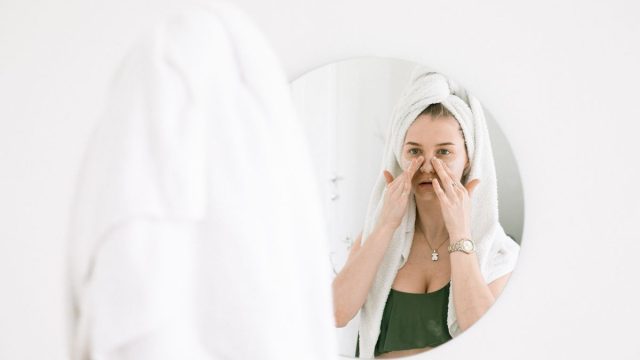 鏡の前でスキンケアする女性