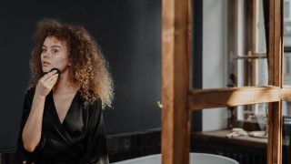 鏡の前でスキンケアする女性