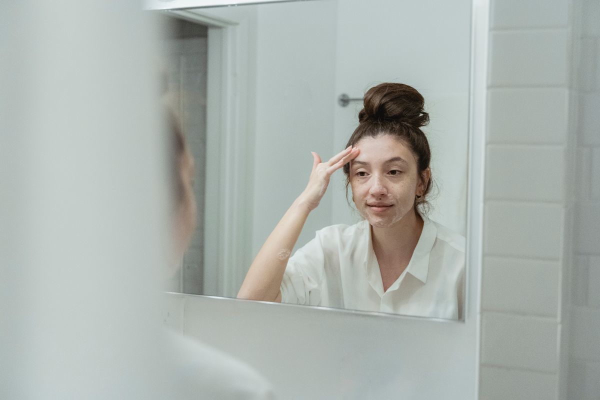 鏡の前でスキンケアする女性