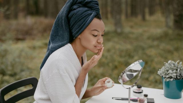 鏡の前でスキンケアする女性