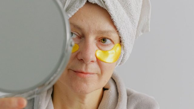 鏡の前でスキンケアする女性