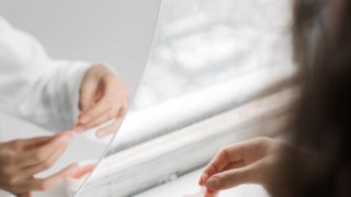 鏡の前でスキンケアする女性