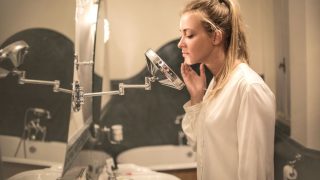 鏡の前でスキンケアする女性