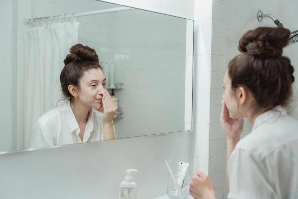鏡の前でスキンケアする女性