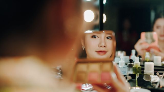 鏡の前でスキンケアする女性