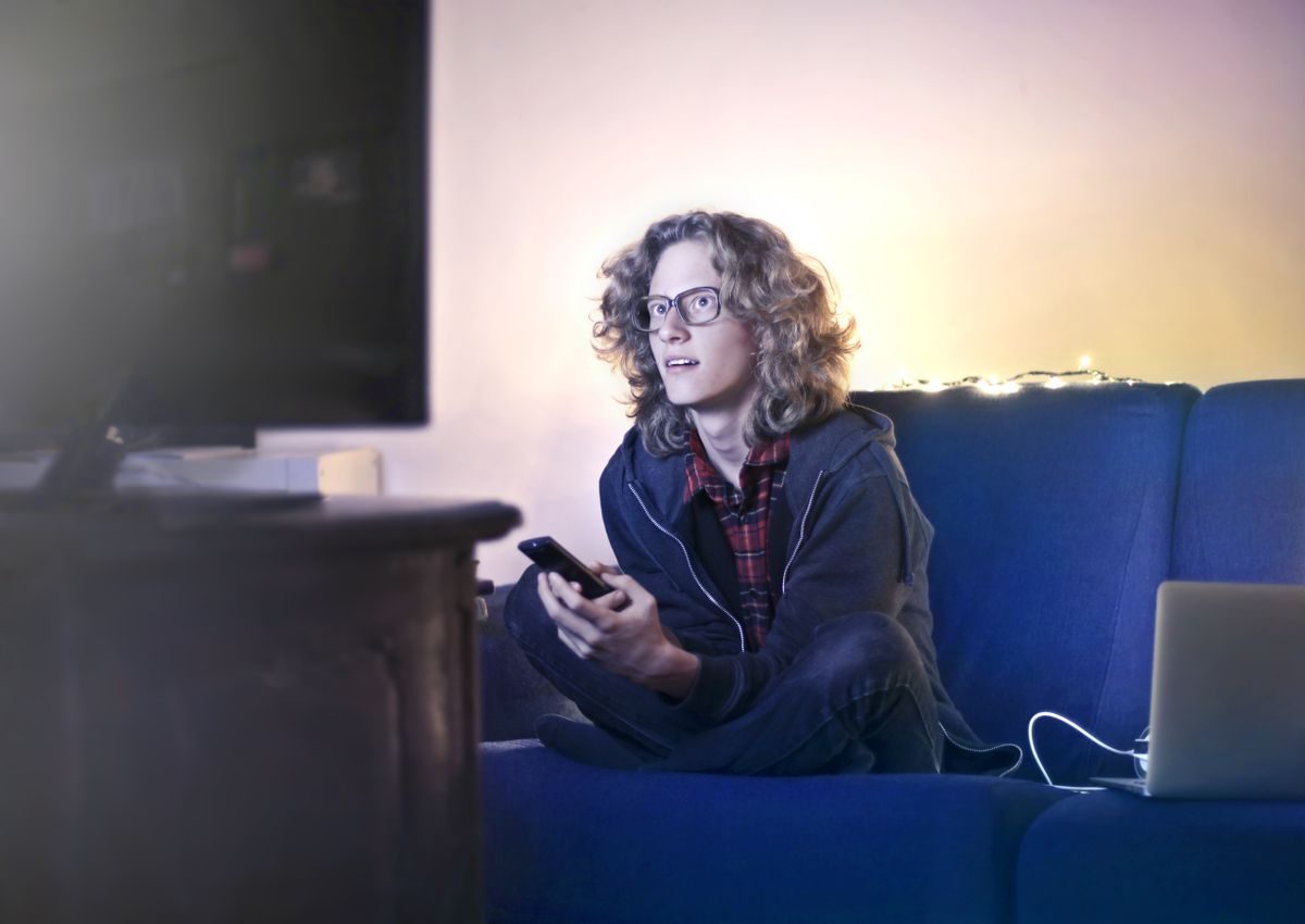リビングでテレビと動画配信を楽しむ男性(VODイメージ)