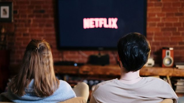 ソファでくつろぎながら動画配信サービスを楽しむカップル
