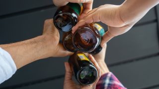 仲間とビールで乾杯する様子|お店での一杯をお得に