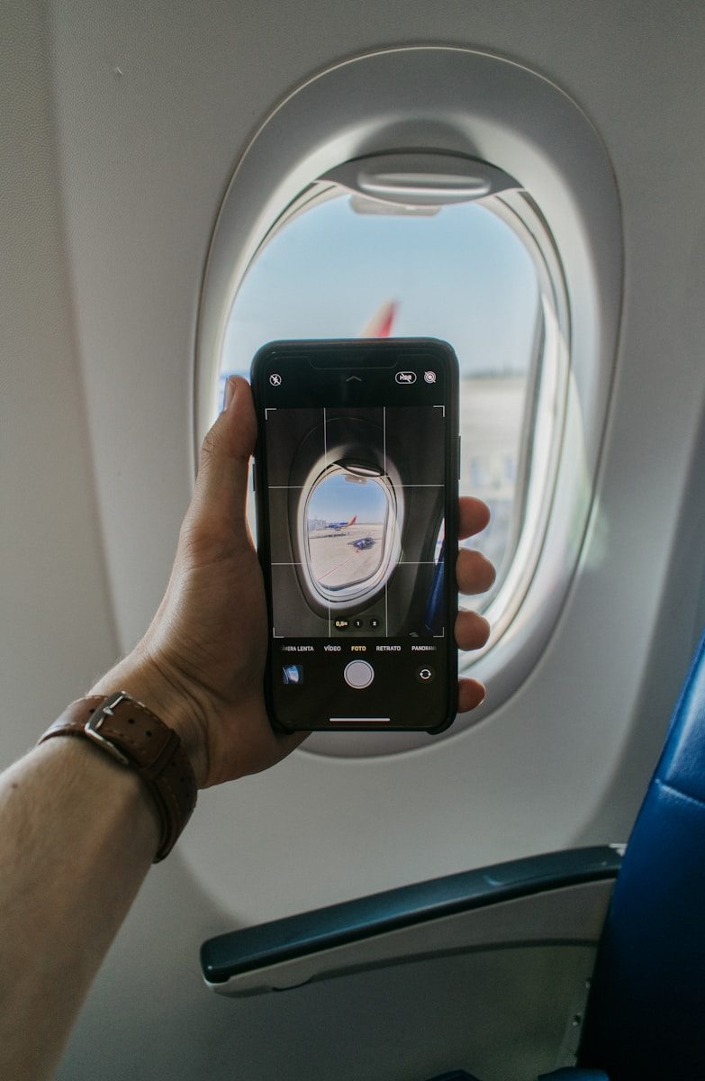 空港の待合スペースでスマートフォンを操作する様子